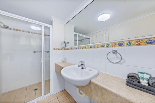 a bathroom with a sink and a shower at Shingley Ocean Views in Airlie Beach