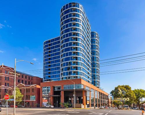 a tall building on a city street with a stop sign at Lumina Suites in Melbourne