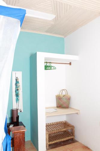 a bedroom with blue walls and a ceiling at Driftwood Beach Lodge in Jambiani