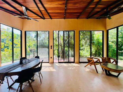 Santa María Huatulco的住宿－4 Villas equipadas con alberca en Huatulco, Oaxaca，配有桌椅和窗户的大房间