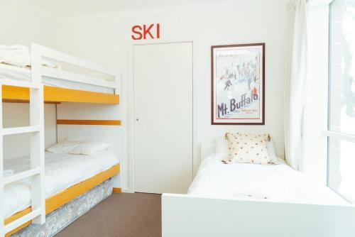 a bedroom with two bunk beds and a window at Reindeer 6 in Mount Buller