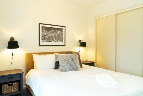 a bedroom with a white bed and two lamps at Reindeer 6 in Mount Buller