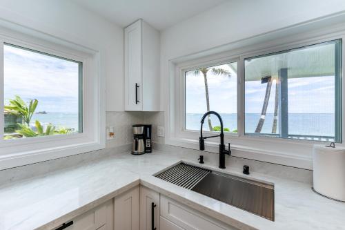cocina con fregadero y 2 ventanas en Beach House - Oceanfront Retreat - Beach Access, en Laie