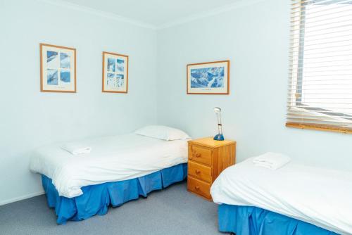 a bedroom with two beds and a dresser in it at Candoux 5 in Mount Buller