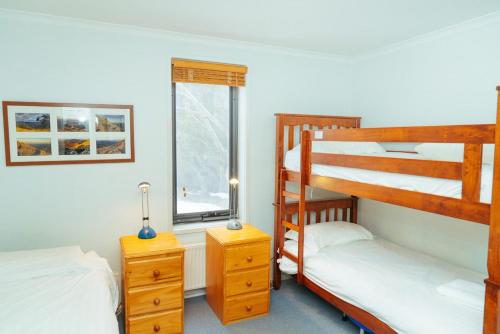 a bedroom with two bunk beds and a window at Candoux 5 in Mount Buller