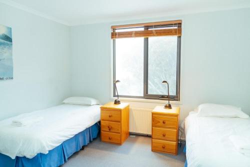 two beds in a room with a window at Candoux 5 in Mount Buller
