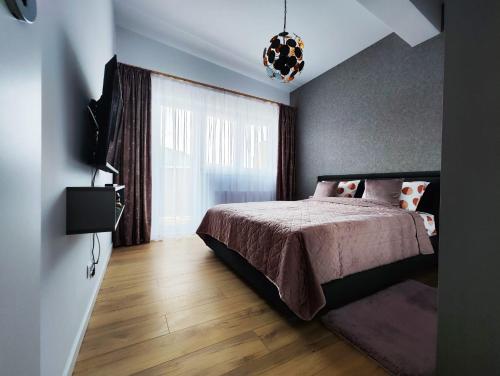 a bedroom with a bed and a window at Mountain Breeze ApartTerrace in Braşov