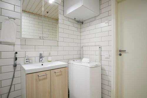uma casa de banho branca com um lavatório e uma máquina de lavar roupa em Fleminginkatu em Turku