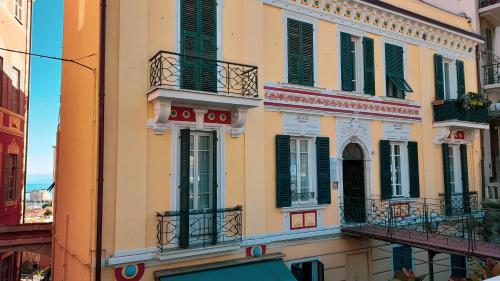 a building with green shutters and balconies on a street at La Casa di Christina in Imperia