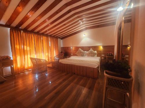 a bedroom with a bed in a room with wooden floors at The Chalets Naldehra in Shimla