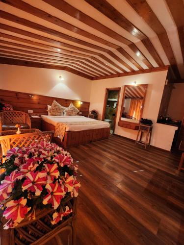 a bedroom with a bed and flowers in a room at The Chalets Naldehra in Shimla