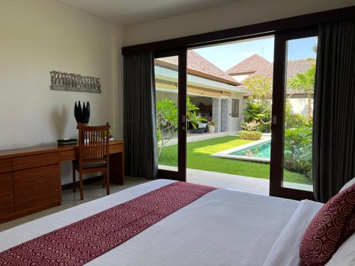 een slaapkamer met een bed, een bureau en een raam bij Oshan Villas Bali in Canggu