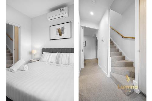a white bedroom with a bed and a staircase at Lumina Suites in Melbourne
