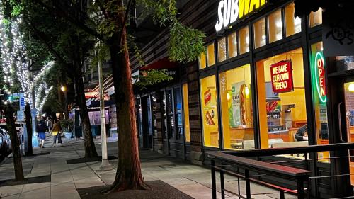 a city street with a bench in front of a store at Cozy home nearby most attractions Seattle center in Seattle