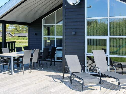 eine Gruppe Stühle und ein Tisch auf einer Terrasse in der Unterkunft 8 person holiday home in Hadsund in Hadsund
