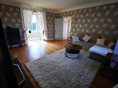 a living room with a couch and a table at Chez Sandrine - Chambres avec pension ou demi pension in Gray-la-Ville