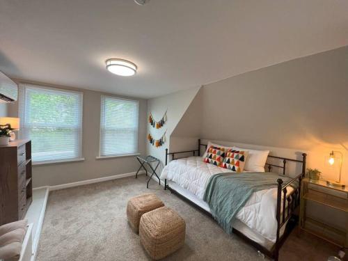 - une chambre avec un lit, une commode et des fenêtres dans l'établissement Cosmopolitan Comfort in St Louis MO, à Tower Grove