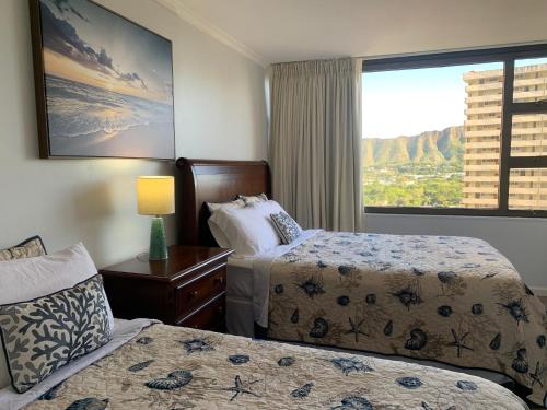 Cette chambre comprend 2 lits et une fenêtre. dans l'établissement Waikiki Banyan 1909 Amazing Views and Just Steps to the Beach, à Honolulu