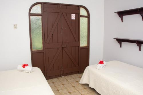 a room with two beds and a wooden door at Casa Carmen in Santiago Este
