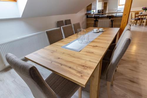 a wooden table with chairs around it in a room at Apartmánový dům Vilémovice in Vilémovice