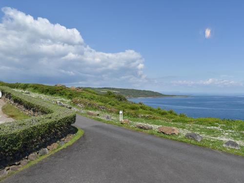 an empty road with a view of the ocean at Headlands Hideaway in Coverack