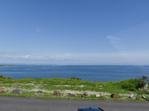 a car parked on the side of a road near the ocean at Headlands Hideaway in Coverack