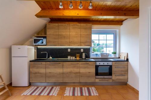 a kitchen with wooden cabinets and a white refrigerator at Apartmánový dům Vilémovice in Vilémovice