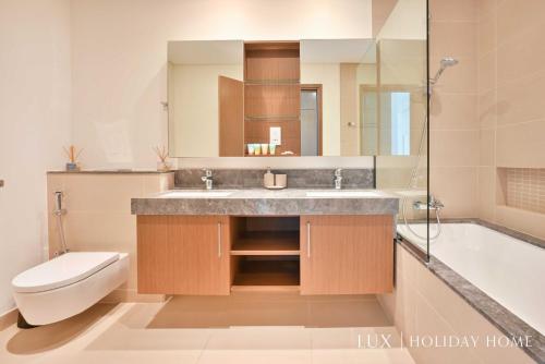 a bathroom with a sink and a toilet and a tub at LUX 52 42 Deluxe Marina view suite 1 in Dubai
