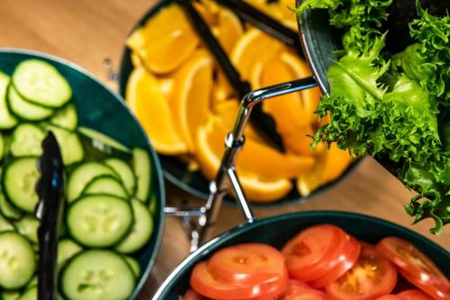 Una mesa con dos platos de verduras y tomates. en Ski-Inn RukaValley, en Ruka