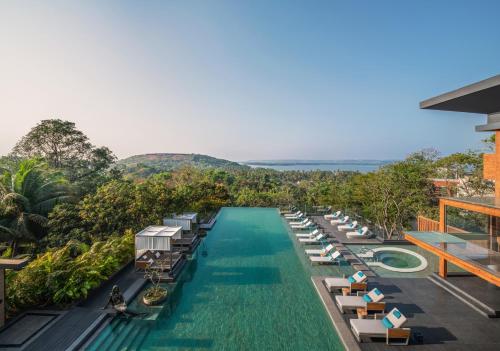 an infinity pool at a resort with lounge chairs at JW Marriott Goa in Vagator