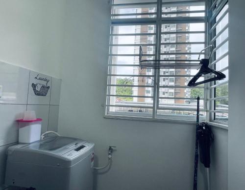 uma casa de banho com um WC e uma janela em LT Home em Sandakan