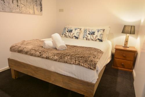 una camera da letto con un letto con un cuscino e un comodino di Christiana 5 AMS Mt Buller a Mount Buller