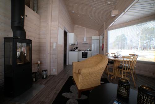 sala de estar con chimenea y mesa con sillas en Pukinsaaren Camping, en Kristinestad