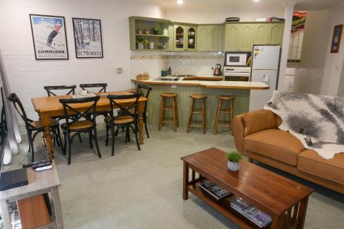 a living room with a couch and a table and a kitchen at Beehive 14 in Mount Buller