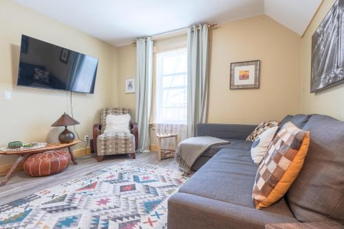 a living room with a couch and a tv at Craftsman's Loft - Heritage charm - AC - 5 min DT in Calgary