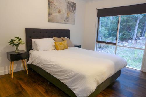 een slaapkamer met een bed en een groot raam bij Rivendell in Merrijig