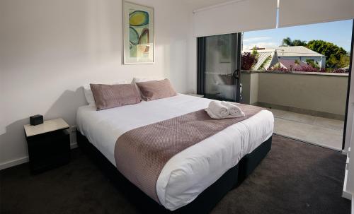 um quarto com uma cama grande e uma janela grande em Quattro On Young em Newcastle