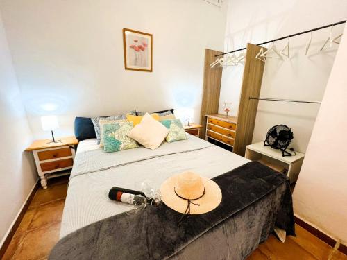 1 dormitorio con 1 cama con sombrero en ALCAMAR Habitaciones en Pisos compartidos cerca al Mar! en Alcalá
