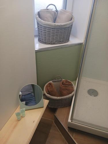 a bathroom with two baskets and a mirror on a shelf at Studio Zen in Boulogne-sur-Mer