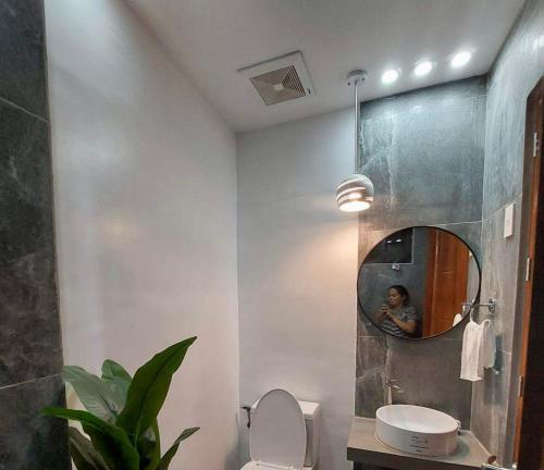 uma casa de banho com WC, espelho e uma pessoa em MARLS PLACE FULLY FURNISHED, 4 mins walk to SM MALL and GAISANO MALL FB name Marls Place em Butuan