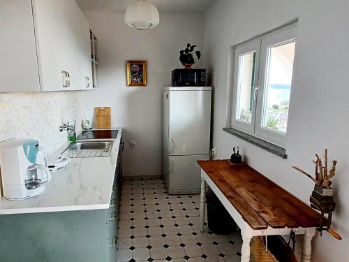 a kitchen with a refrigerator and a table in it at Apartments Starshine & Lighthouse in Zečevo
