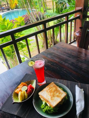 a table with a plate of food and a drink at Lullaby Bungalows in Uluwatu