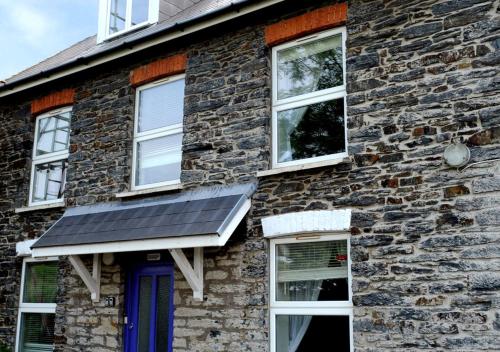 una casa con un panel solar a un lado. en Eluned Tresaith, en Penbryn