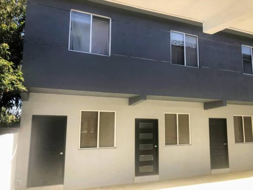 a building with black doors and windows on it at D2 Hermoso condominio privado in Tijuana