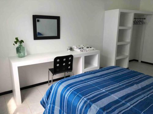 a bedroom with a bed and a desk with a mirror at D2 Hermoso condominio privado in Tijuana