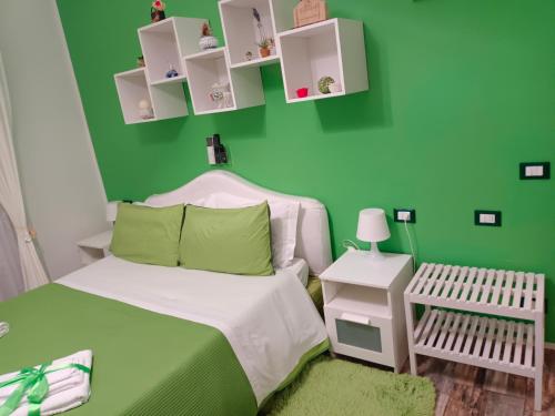 Dormitorio verde con cama y pared verde en appartamento in firenze la lamma, en Florencia