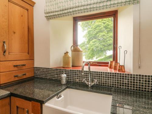 uma cozinha com um lavatório e uma janela em The Arches Larklands em Richmond