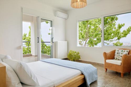 ネオス・マルマラスにあるSithonian Villaのベッドルーム1室(ベッド1台、椅子、窓付)