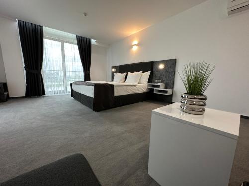 sypialnia z łóżkiem oraz waza z rośliną w obiekcie Del Ponte w mieście Swilengrad