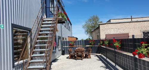 a patio with a ladder and a table and chairs at Kambarių nuoma Naujojoje Akmenėje in Naujoji Akmenė